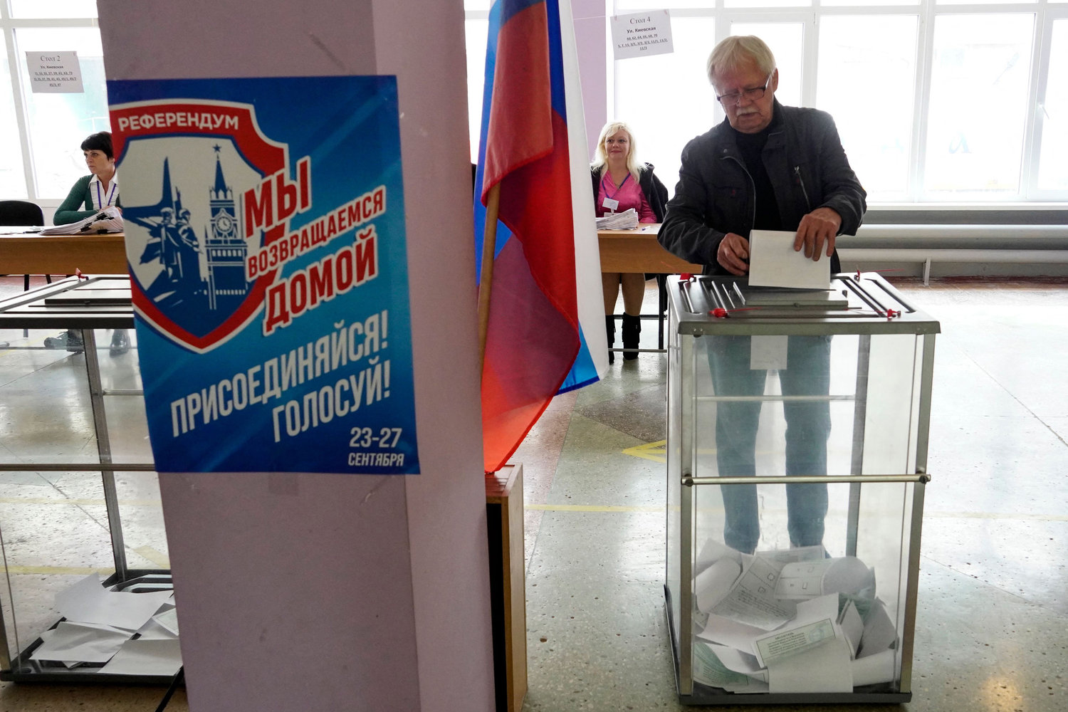 A man casts his ballot for a referendum at a polling station in Mariupol on September 27, 2022. The placard reads "Referendum. We are returning home. Join! Vote!". - Western nations dismissed the referendums in Kremlin-controlled regions of eastern and southern Ukraine as the voting on whether Russia should annex four regions of Ukraine started on September 23, 2022. (STRINGER/AFP via Getty Images/TNS)